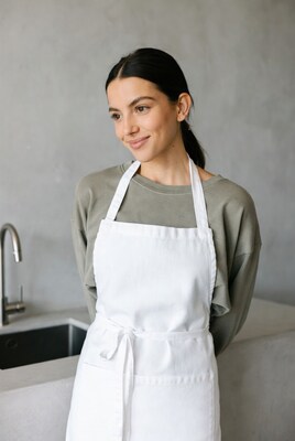 Woman in white apron by kitchen sink