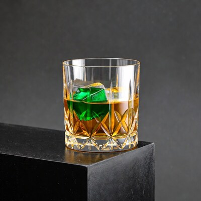 Whiskey glass with green ice cube