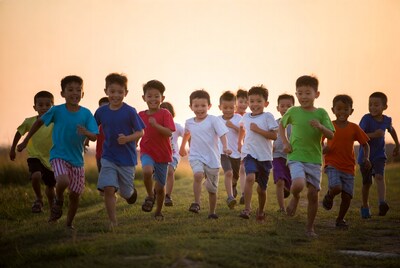 Asian boys running on grass at sunset