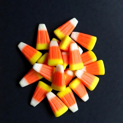 Candy corn pile on black background