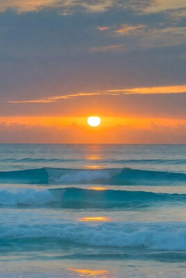 Sunrise over ocean waves