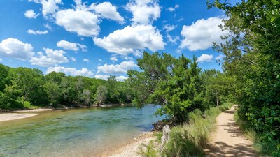 River with trail and green trees