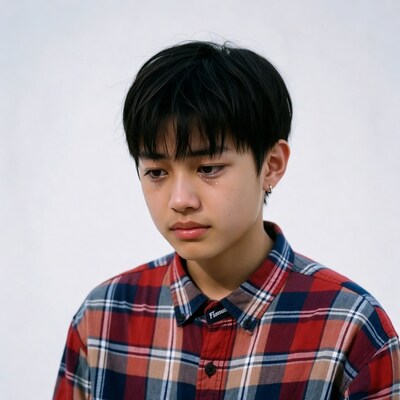 Asian boy with tears in plaid shirt