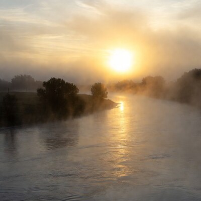 Sunrise over misty river