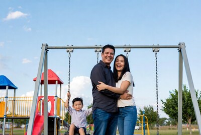 Asian family with boy on playground swing