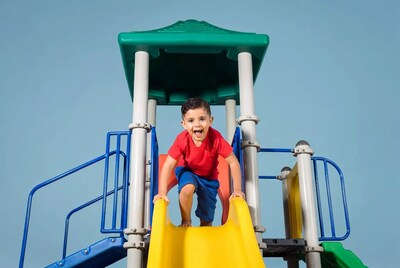 Boy sliding down playground slide