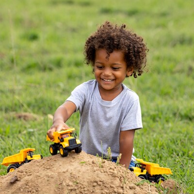 Black boy playing with toy dump trucks