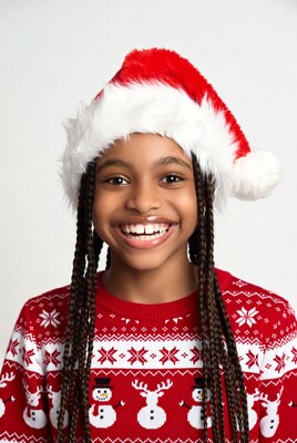 African-American girl in Santa hat smiling