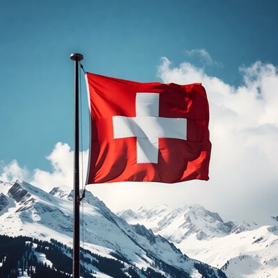 Swiss Flag on Pole with Snowy Mountains