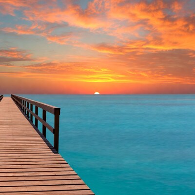 Wooden pier at sunset over turquoise sea