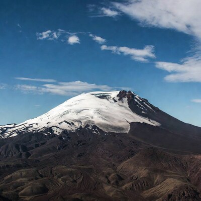 Snow-capped volcano under blue sky