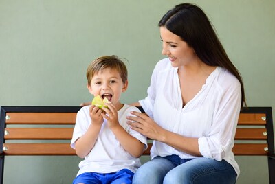 Boy eating green apple with mom