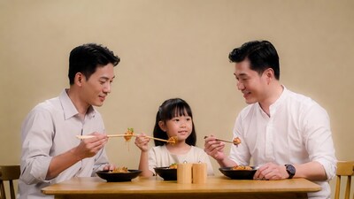 Asian family eating noodles with chopsticks