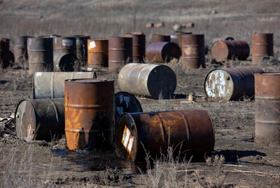 Rusty oil drums in barren field