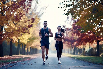 Couple running autumn forest path