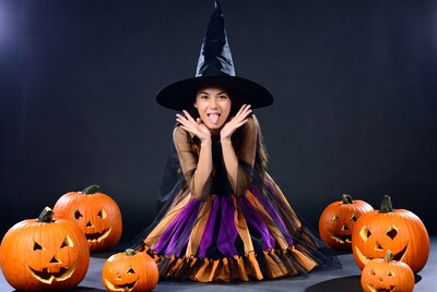 Asian woman in witch costume with jack-o-lanterns