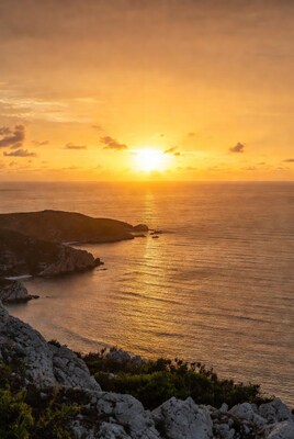 Sunset over rocky cliffs and ocean