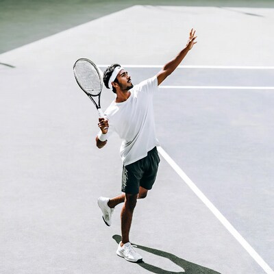 Man serving tennis racket on court