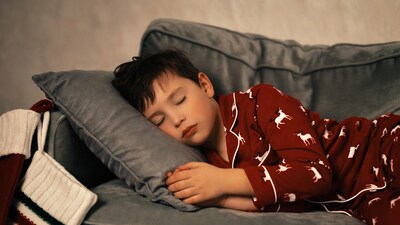 Boy sleeping in reindeer pajamas on couch
