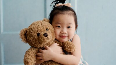Asian girl hugging teddy bear