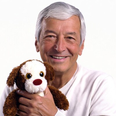 Elderly man holding plush dog