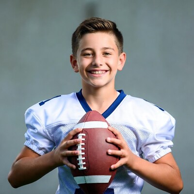 Boy holding football in jersey