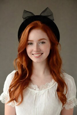 Redhead woman in black hat smiling