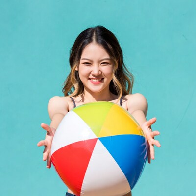 Asian woman holding colorful beach ball