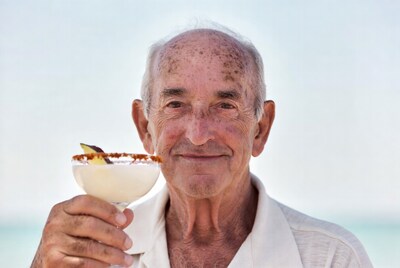 Elderly man holding margarita glass