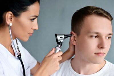 Doctor examining boy's ear