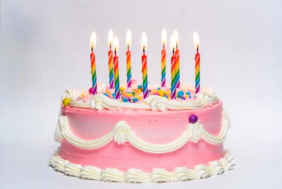 Pink birthday cake with rainbow candles