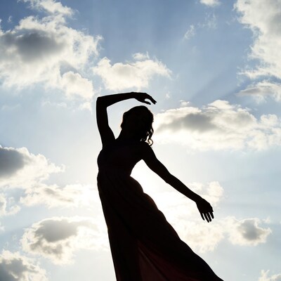 Woman dancing silhouette against sunset sky