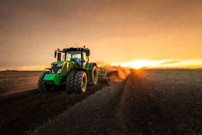 Green John Deere Tractor Plowing Field at Sunset