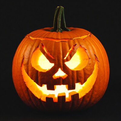 Lit Jack-o'-lantern pumpkin on black background