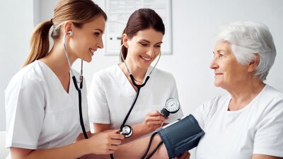Nurses checking blood pressure on elderly woman