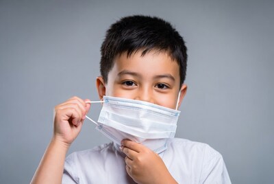 Asian boy holding face mask