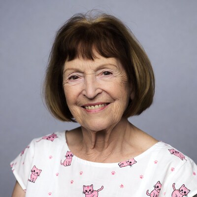 Elderly woman smiling in cat print top