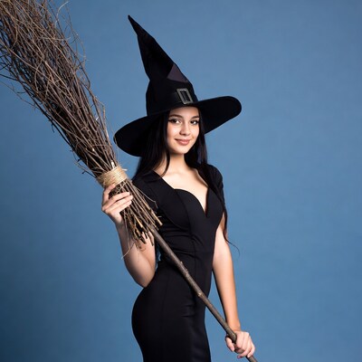 Woman in witch costume holding broom
