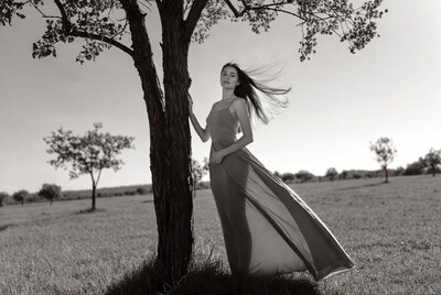 Woman in flowing dress by tree