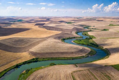 Aerial view of river winding through farmland