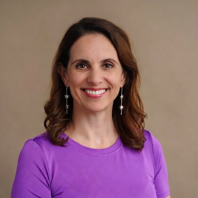 Smiling woman in purple top with star earrings