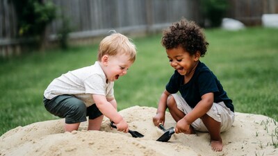 Two boys playing with shovels in sand