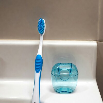 Blue toothbrush and holder on sink