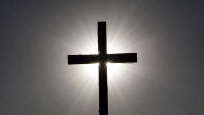 Silhouette cross with sun rays
