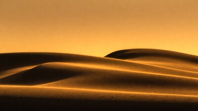 Golden desert dunes at sunset