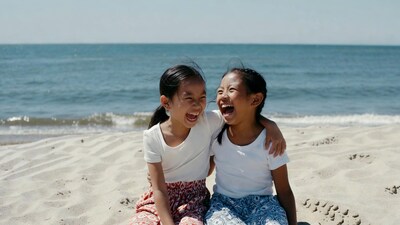 Asian girls laughing on beach