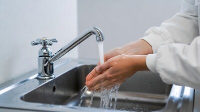 Woman washing hands under faucet