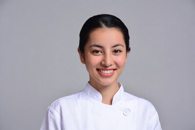 Asian woman smiling in white chef uniform