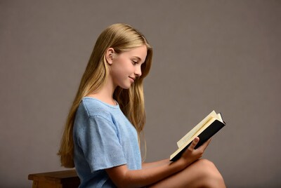 Girl reading book in blue sweater