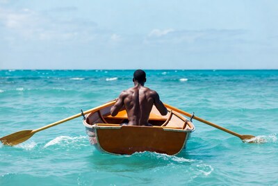 African-American man rowing boat in ocean